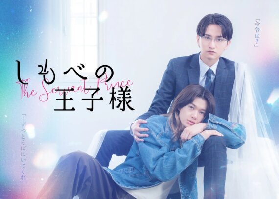 Two young men pose closely together on a pastel poster, one in a suit and the other in a denim jacket, with Japanese text overlays.