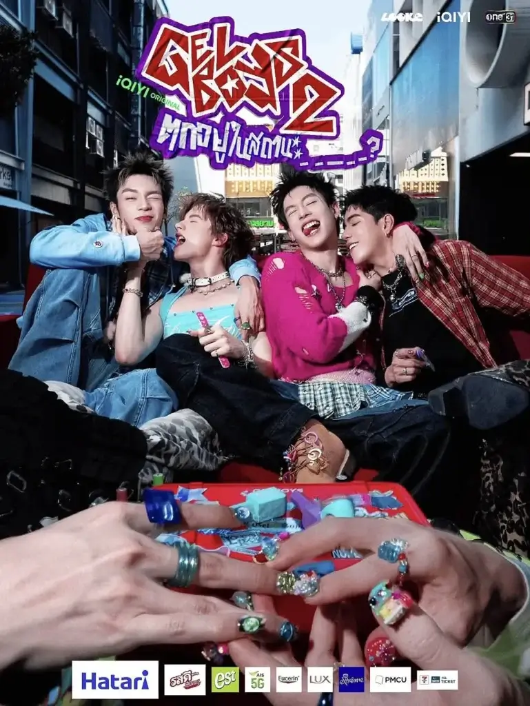 Five stylish friends sit close together in a red car on a city street, laughing and showing off colorful accessories and nail art.
