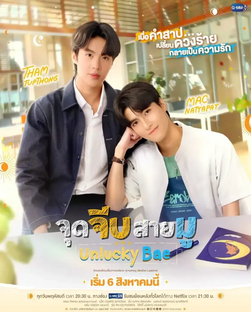 Two young men pose together indoors; one stands in a denim jacket while the other leans his head on his shoulder, as a colorful poster for 'Unlucky Bae' is shown behind them at a cafe.
